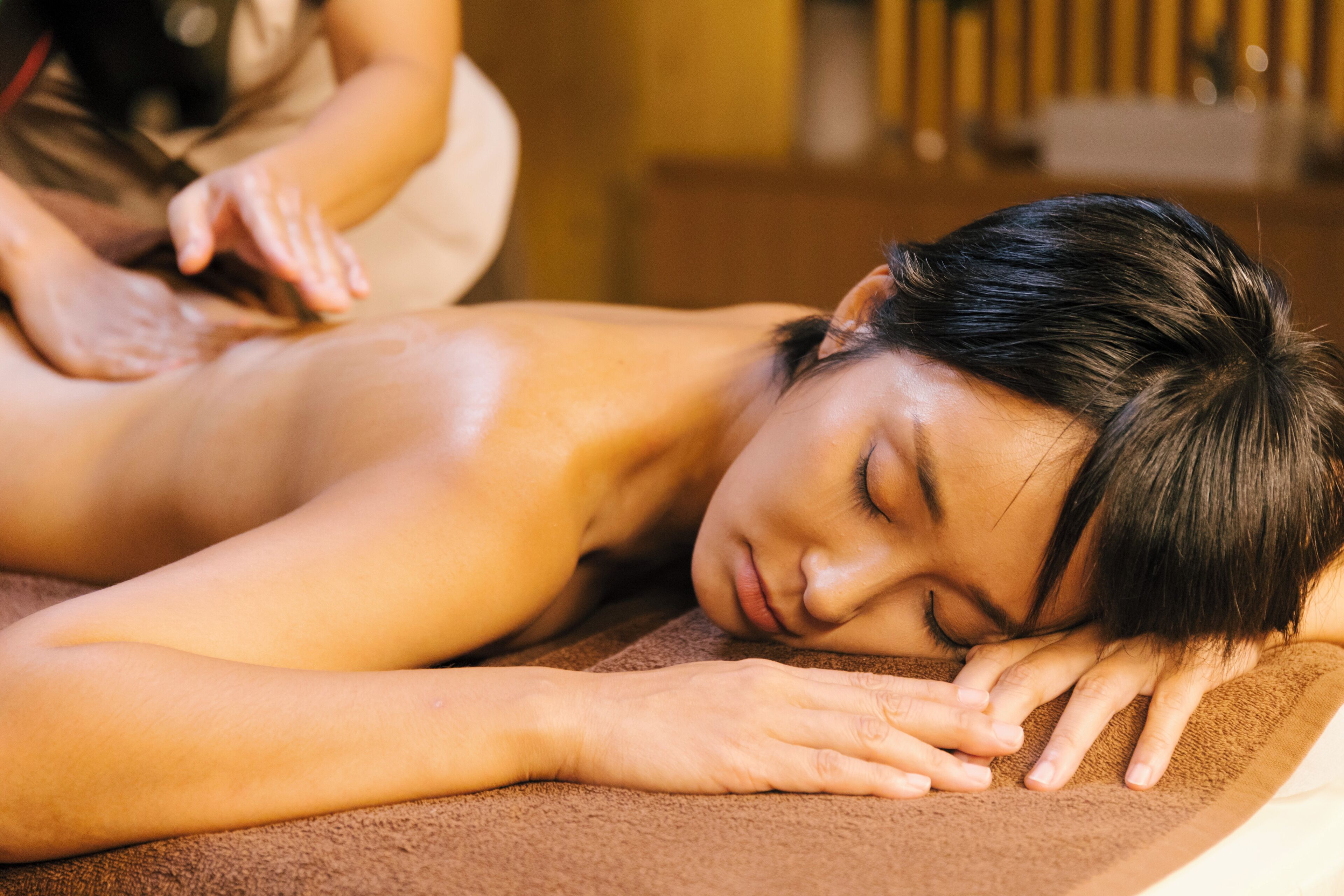 A person receiving a massage on a massage table.
