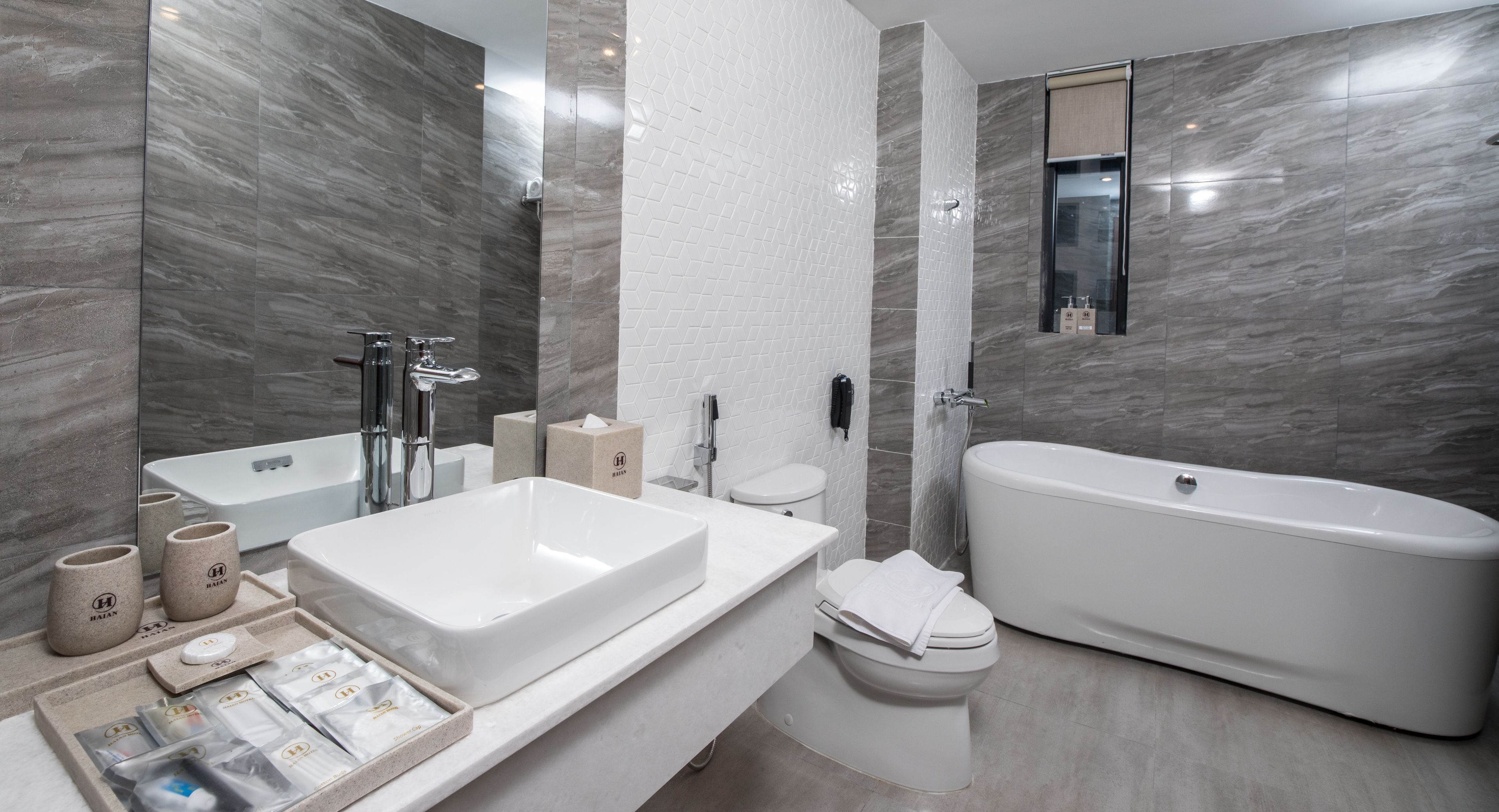 A modern bathroom with a large bathtub, a separate shower area, and a vanity with a sink and mirror.