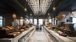 A spacious buffet area with a variety of food items and a patterned floor. - HAIAN Beach Hotel & Spa (Da Nang)