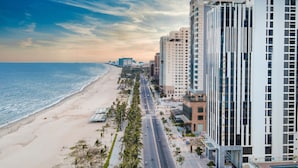 A coastal cityscape with a beach, high-rise buildings, and a clear sky. - HAIAN Beach Hotel & Spa (Da Nang)