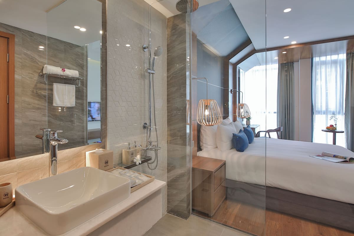 A modern bathroom with a large bathtub, a glass-enclosed shower, and a wooden vanity.