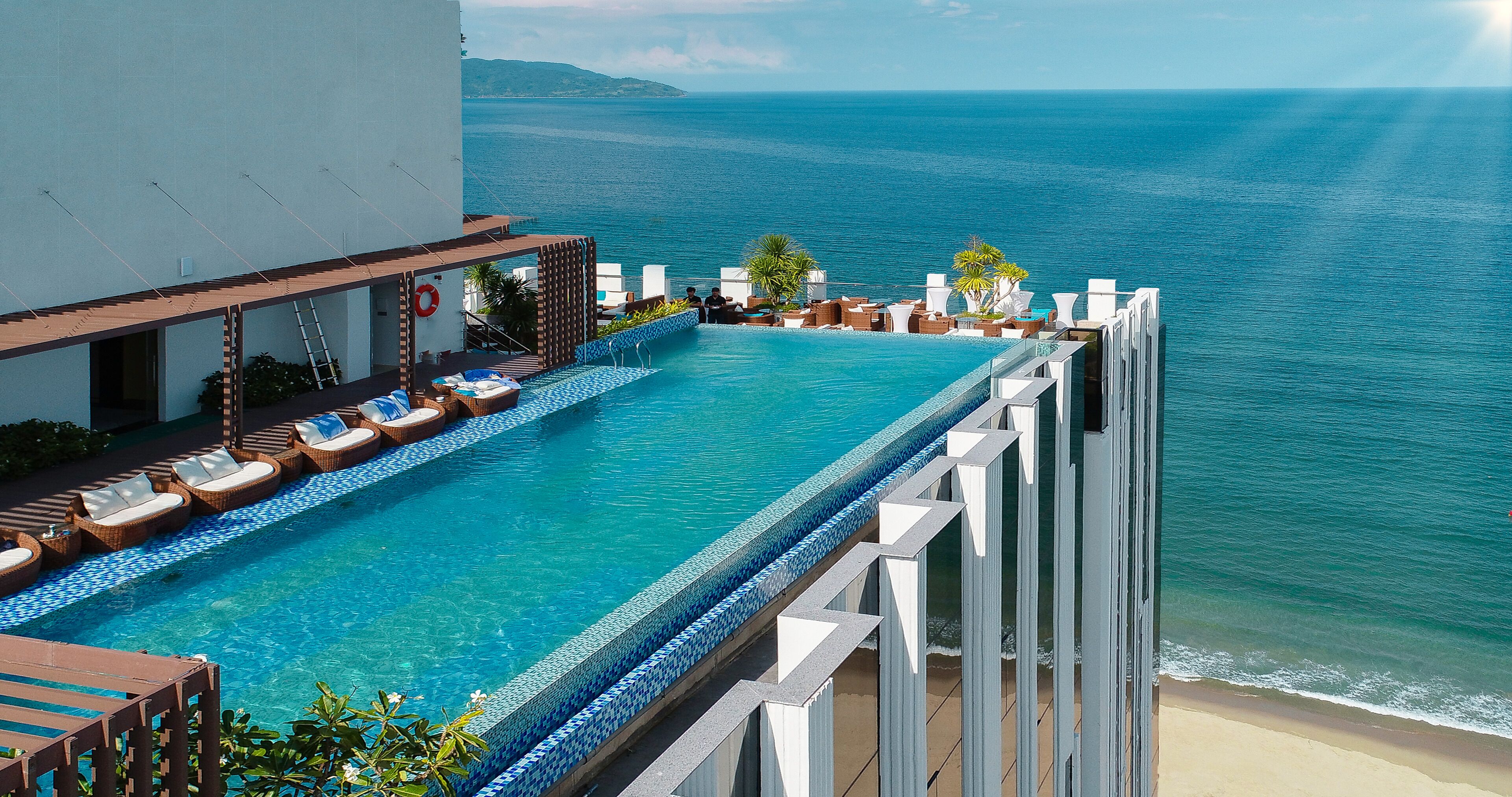 An infinity pool with a view of the ocean, lounge chairs, and a lifebuoy.