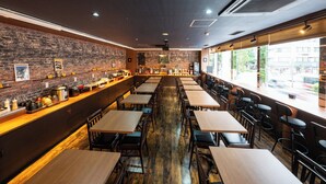 A restaurant with brick walls, wooden tables, and chairs.