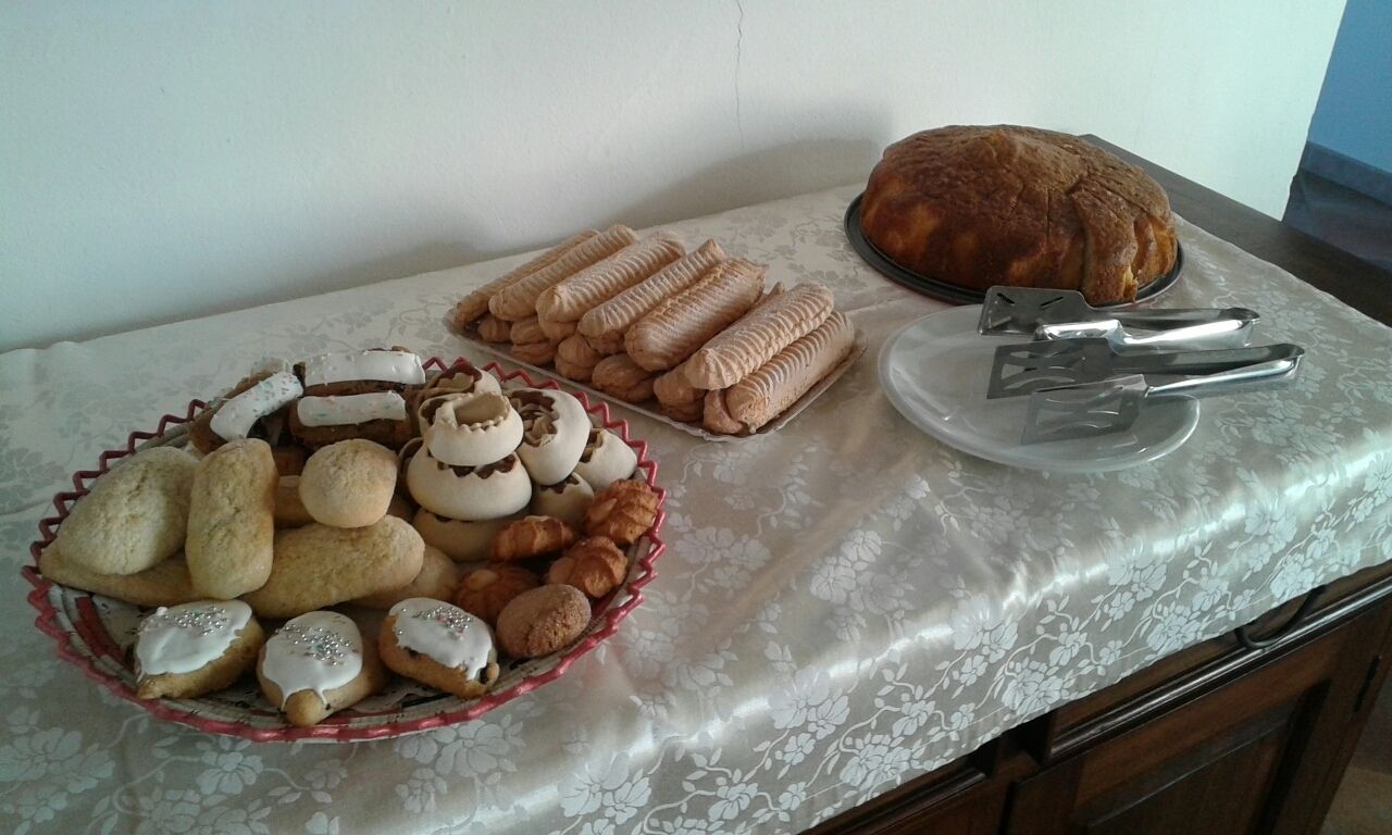 A table with various baked goods, including cookies and a loaf of bread.
