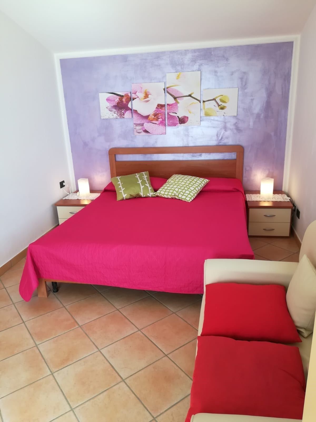 Ein Schlafzimmer mit einem Bett, einem Nachttisch und einem Sessel.
