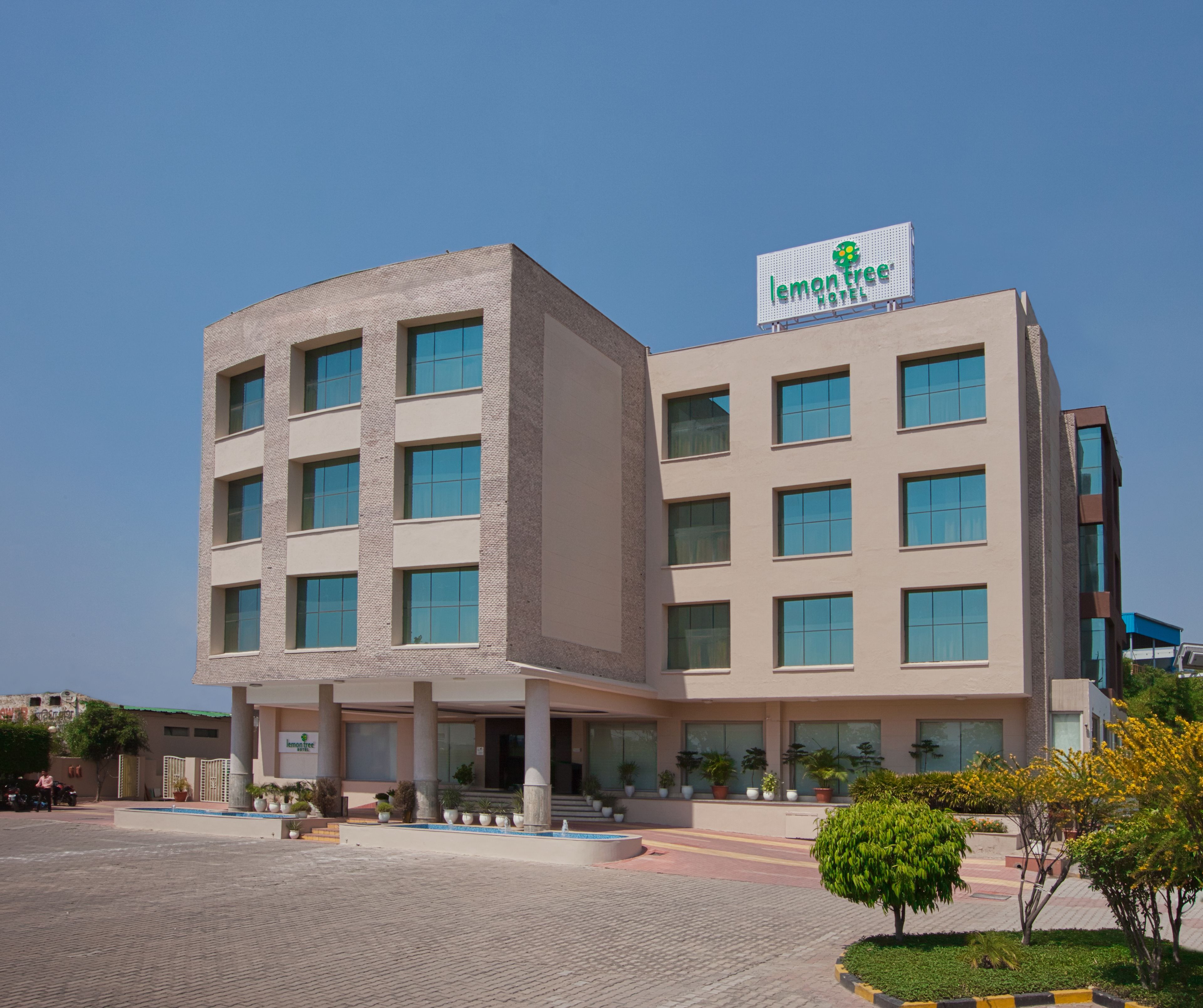 A modern hotel building with a prominent sign for 'lemontree hotels'.