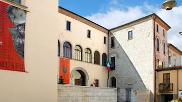 Ein Gebäude mit einem Schild für Museo Palazzio Lofredo, mit einer steinernen Fassade und Rundbogenfenstern.