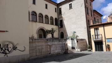 Un patio con un edificio de fachada de ladrillo y ventanas de arco.
