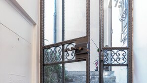 A narrow, glass door with metal bars and a decorative design, leading to a stone staircase. - La Cantina del Convento (Potenza)