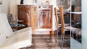 A room with a patterned carpet, a wooden cabinet, a framed picture on the wall, and a window with a curtain. - La Cantina del Convento (Potenza)