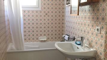 A bathroom with a bathtub, a sink, and a shower.