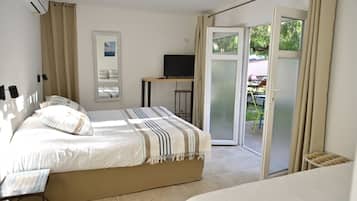 Chambre Triple Confort, terrasse, vue jardin | Literie de qualité supérieure, coffres-forts dans les chambres
