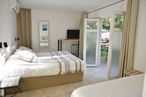 Chambre triple Confort, terrasse, vue sur le jardin | Literie de qualité, coffre-fort, décor unique, ameublement unique