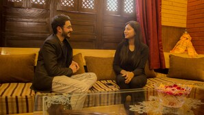 A room with a wooden wall, a sofa, and a glass table with a decorative bowl. - Hotel Stargaze (Kathmandu)