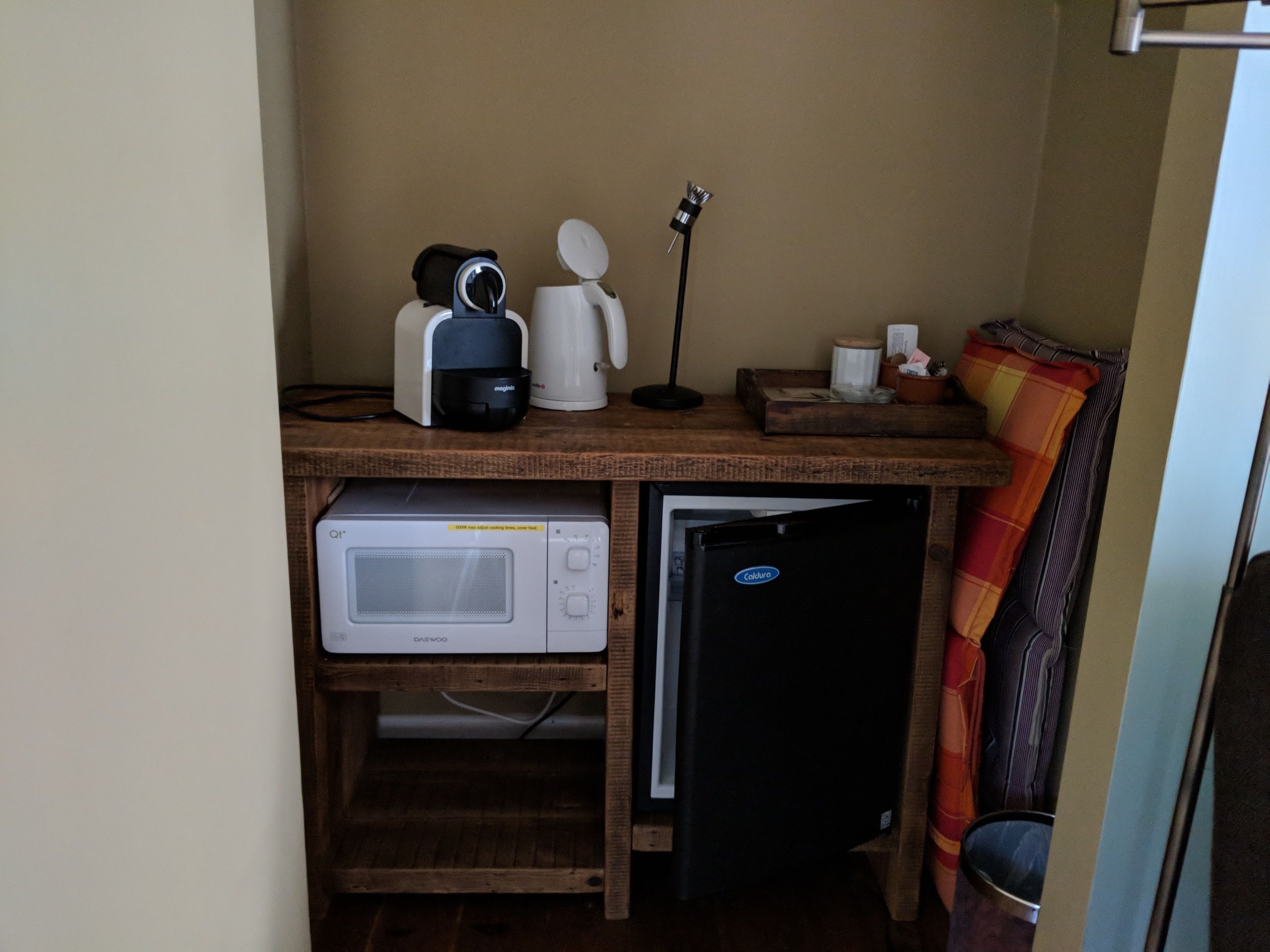 Une petite cuisine équipée d’un four à micro-ondes, d’une machine à café et d’un mini-réfrigérateur.