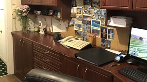 A wooden desk with a computer, phone, and various papers. - Warwick Lodge (Surbiton)