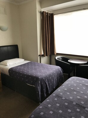 Una habitación de hotel con cama, una mesita y una silla.