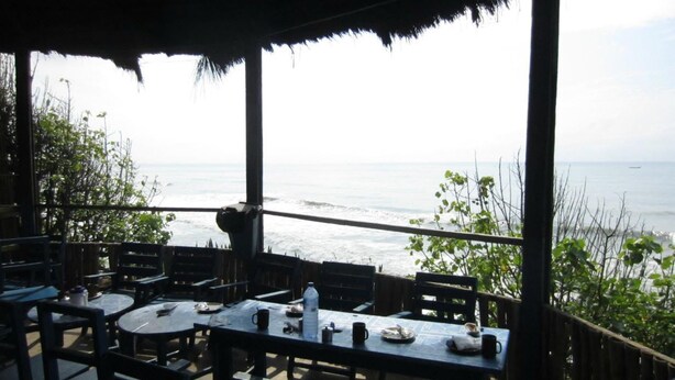 A seaside restaurant with tables and chairs, overlooking the ocean. - Rising Phoenix Magic Beach Resort (Accra)