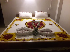 A bed with a heart-shaped decoration made of flowers and a swan design in the center. - Sunrise Beach Resort (Port Blair)