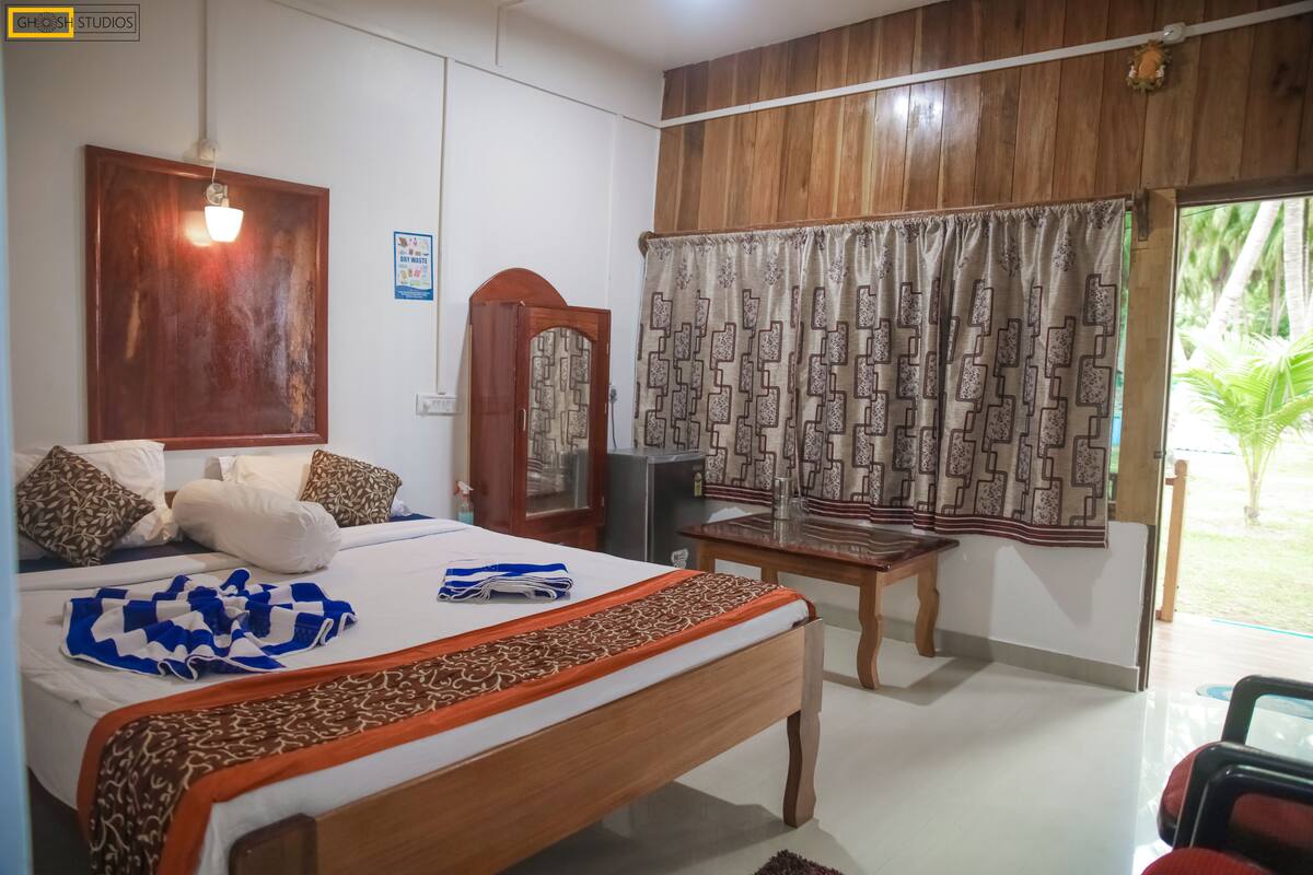 A hotel room with a wooden bed, a desk, a television, and a view of the outdoors.