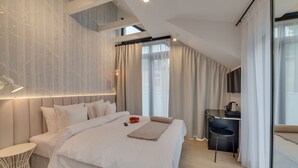 Une chambre moderne avec un grand lit, un bureau, une chaise et un téléviseur.