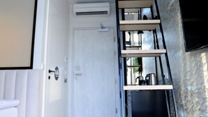 Un intérieur moderne avec un escalier en bois, une porte blanche et un mur en pierre.