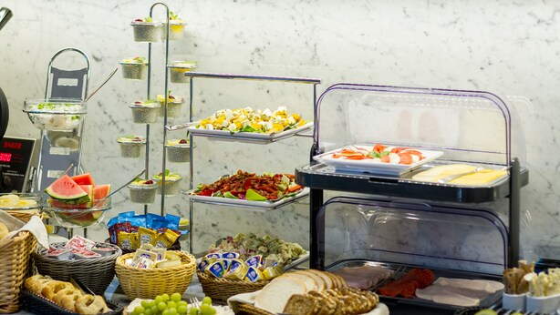 Un buffet proposant une variété d’aliments, notamment des fruits, des fromages et du pain.