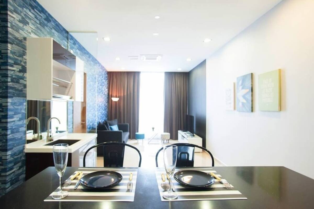 Een moderne hotelkamer met een zithoek, kitchenette en woonruimte.