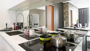 A modern kitchen with a black countertop, stainless steel appliances, and a large window.