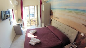 A hotel room with a large bed, a painting of a beach scene, a TV, and a sliding door leading to a balcony. - Tropeacentro (Tropea)