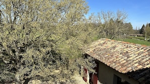 A rustic building with a tiled roof and a tree in the foreground. - Chambres d'hôtes Le Puy d'Anché (Sauzé-Vaussais)
