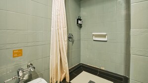 Ein Badezimmer mit Duschvorhang, Toilette, Waschbecken und Seifenspender.