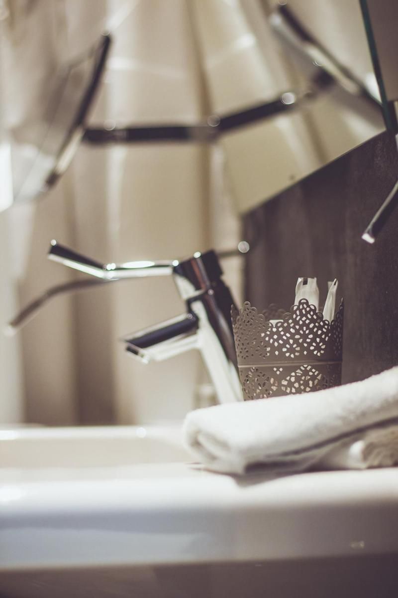 Un lavabo de salle de bain doté d’un robinet moderne et d’un panier décoratif en métal.