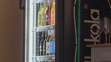 Un refrigerador lleno de diversas bebidas y un cartel que dice 'TRUSTBAR'.