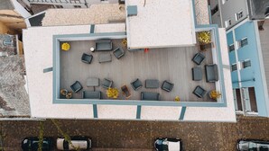 Luchtbeeld van een terras op een dak met een zitgedeelte, een kleine tuin en een parkeerplaats.