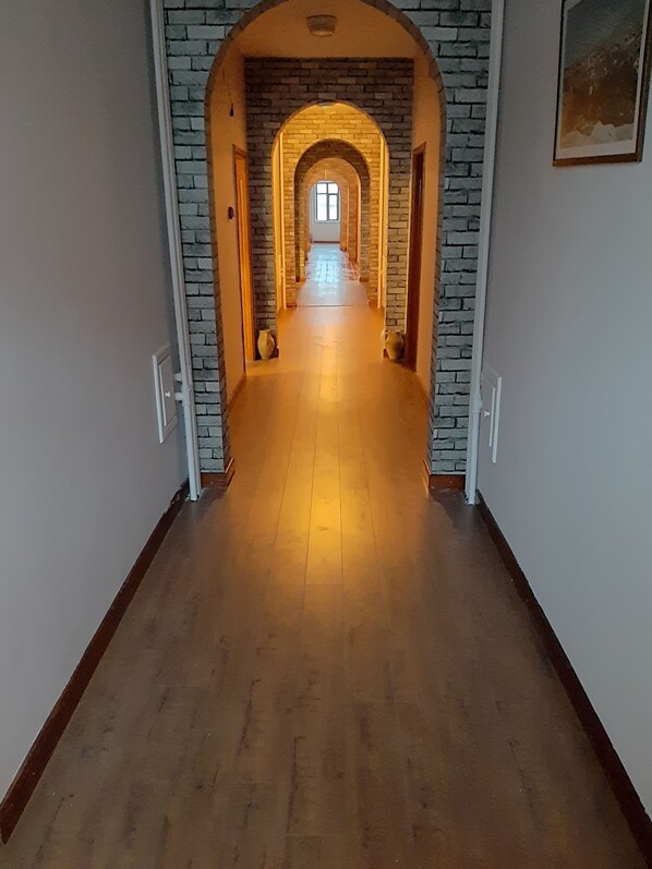 Un pasillo con un arco de ladrillo que da a una ventana.