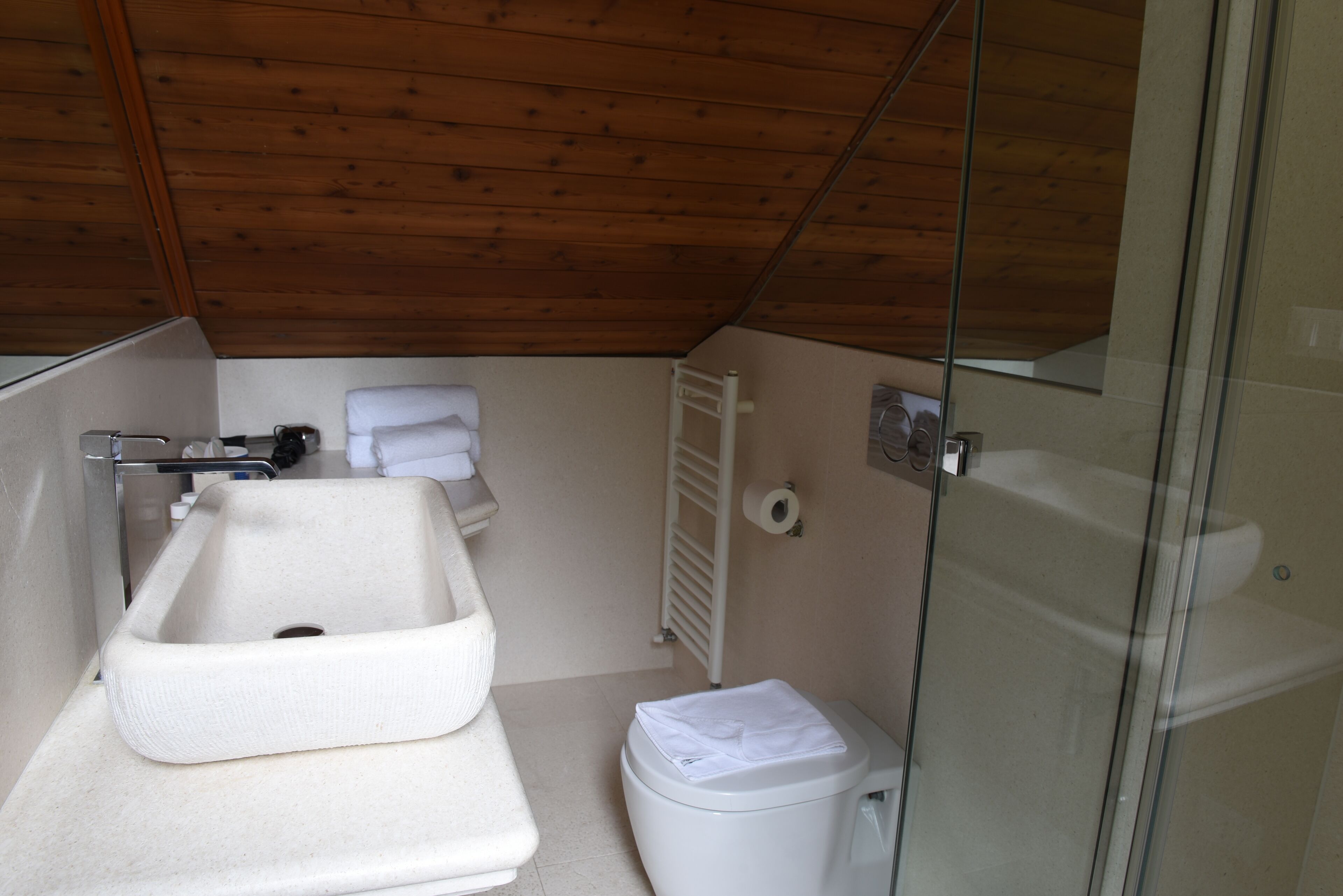 Une petite salle de bain comprenant un lavabo, des toilettes et une douche à parois de verre.