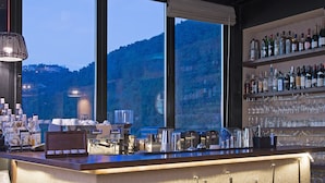 A bar area with a large island, bar equipment, and a view of the outdoors. - Bkerzay (Deir Dourite)