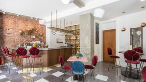 Un espace bar moderne avec un mur en briques, des tabourets de bar, un comptoir central et un présentoir à bouteilles de vin.