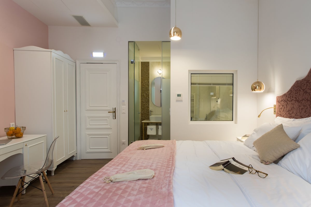 Un dormitorio con cama, mesita de noche y escritorio con silla.