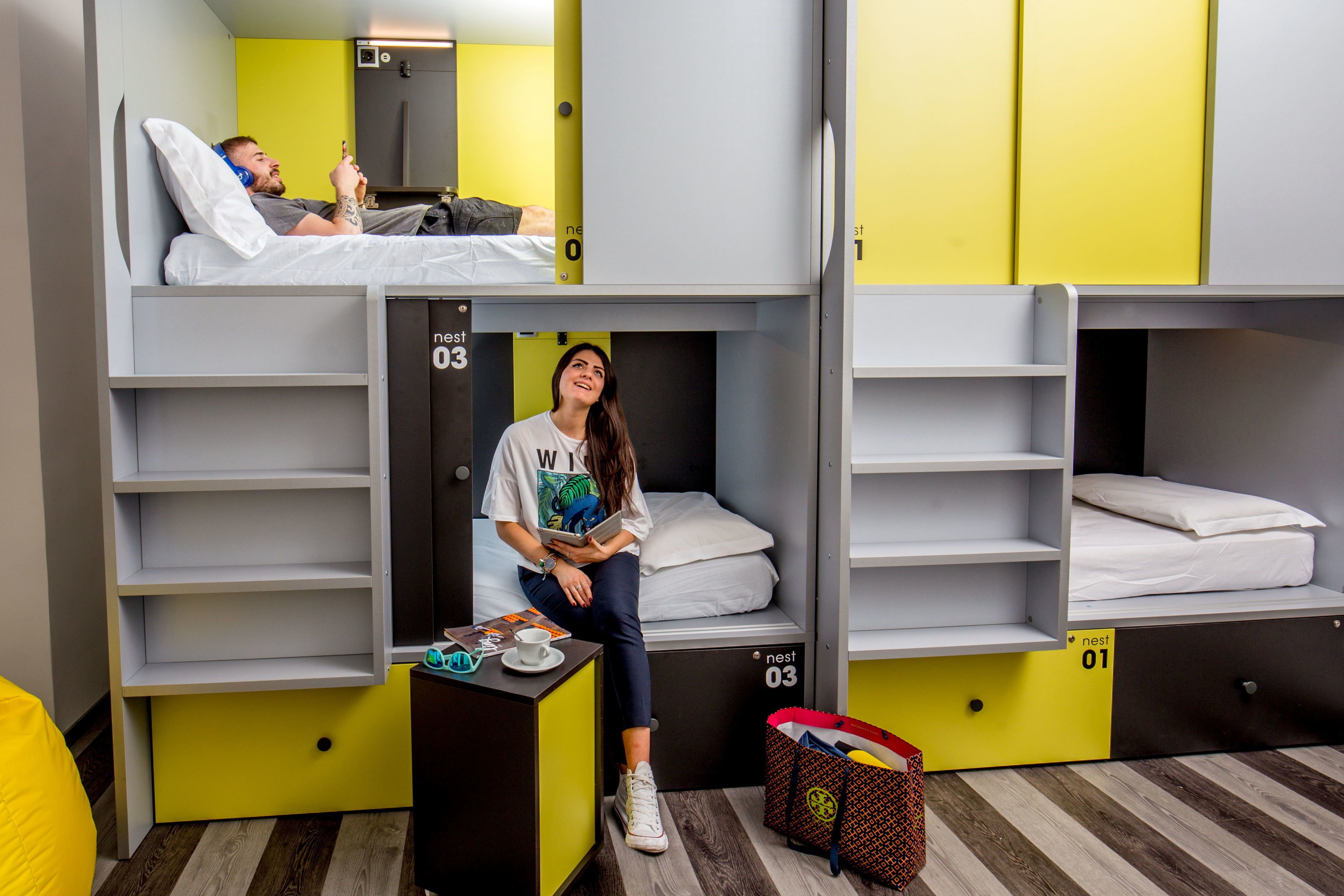 A dormitory room with bunk beds, a desk, and a chair.
