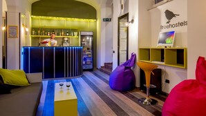 A modern interior with a bar area, seating, and a sign for freehostels. - Free Hostels Roma (Rome)