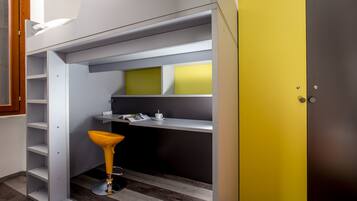 A compact room with built-in shelving, a yellow cabinet, and a stool.