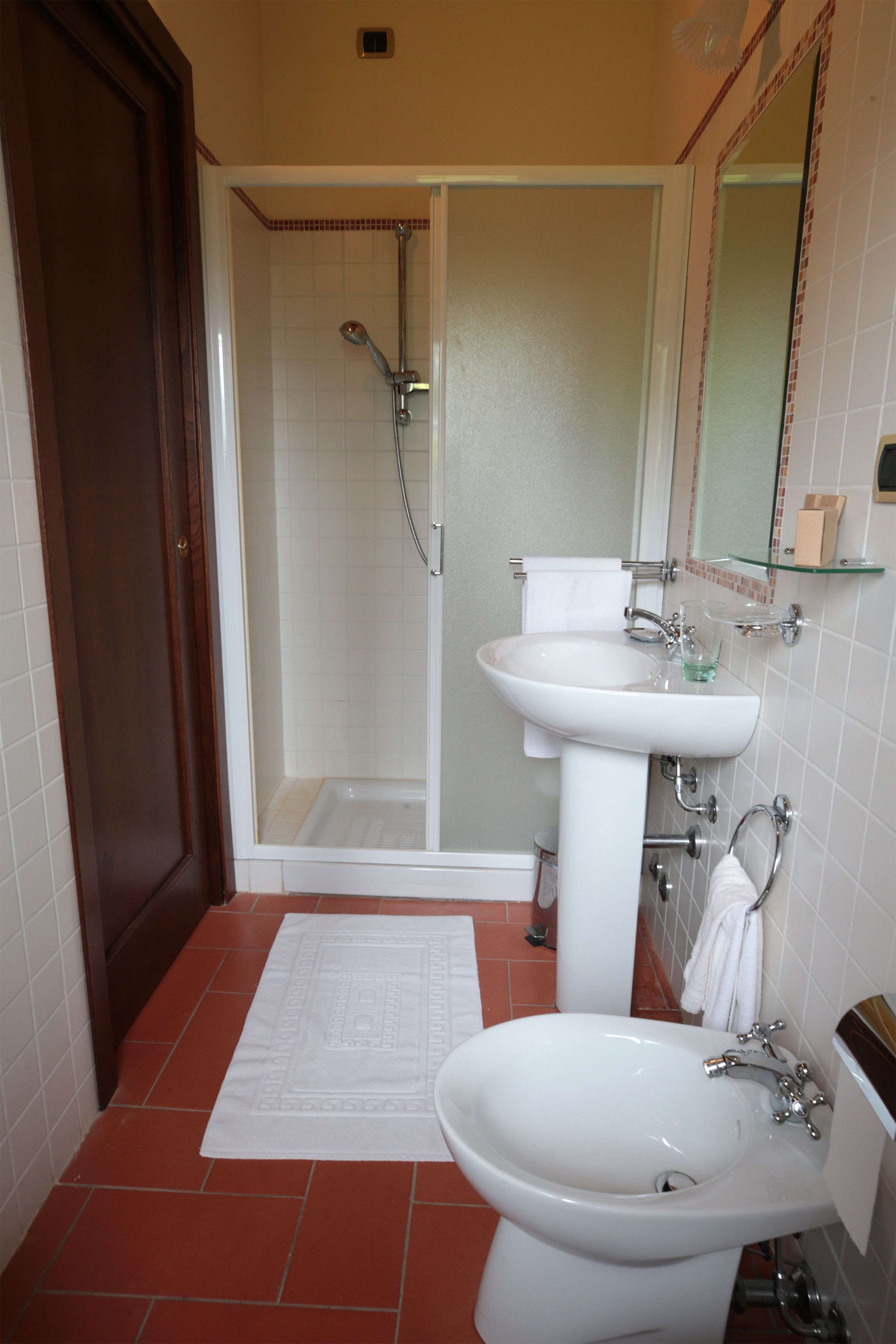 Un baño con ducha, lavamanos e inodoro.