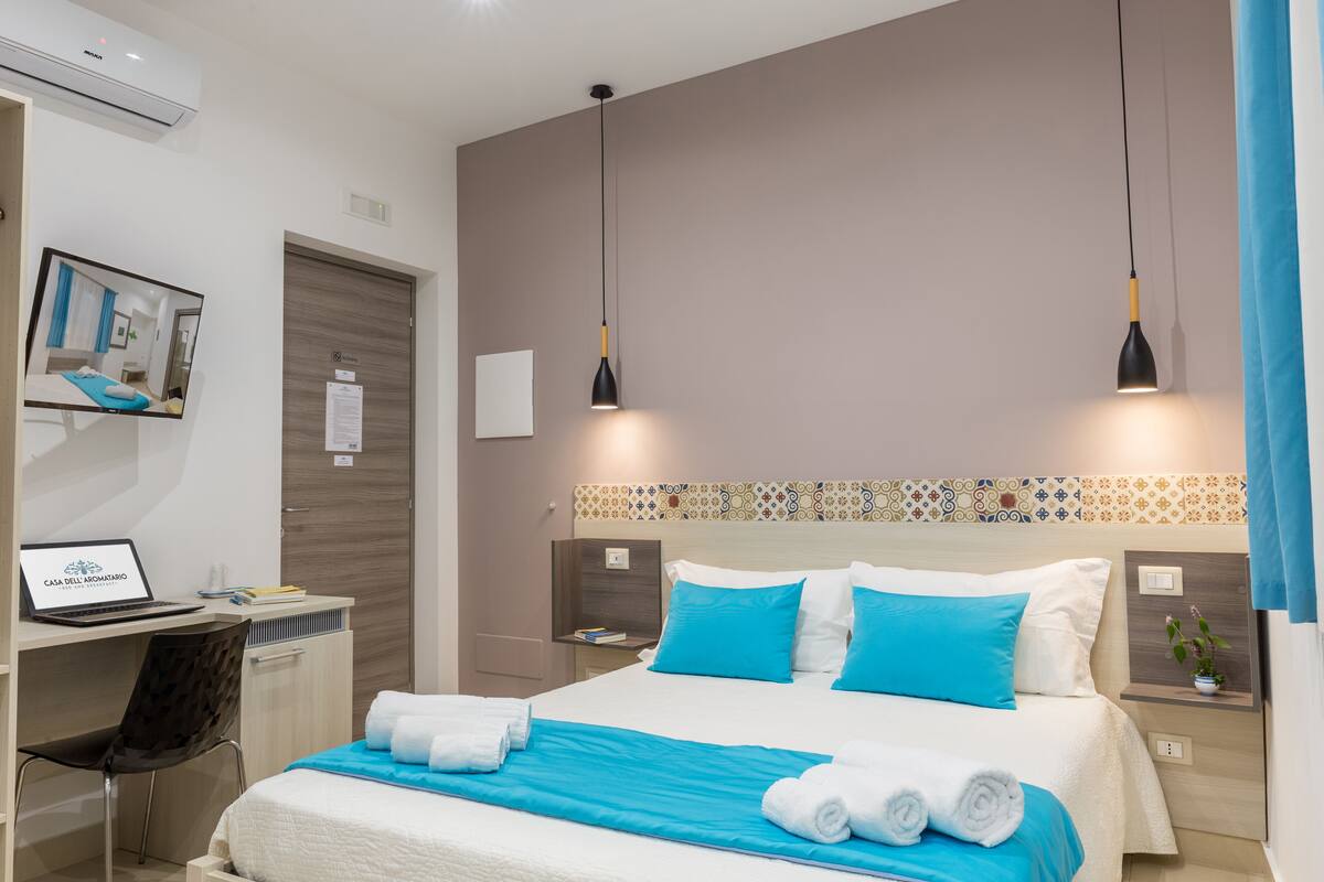 Una habitación de hotel moderna con cama, escritorio y ordenador.