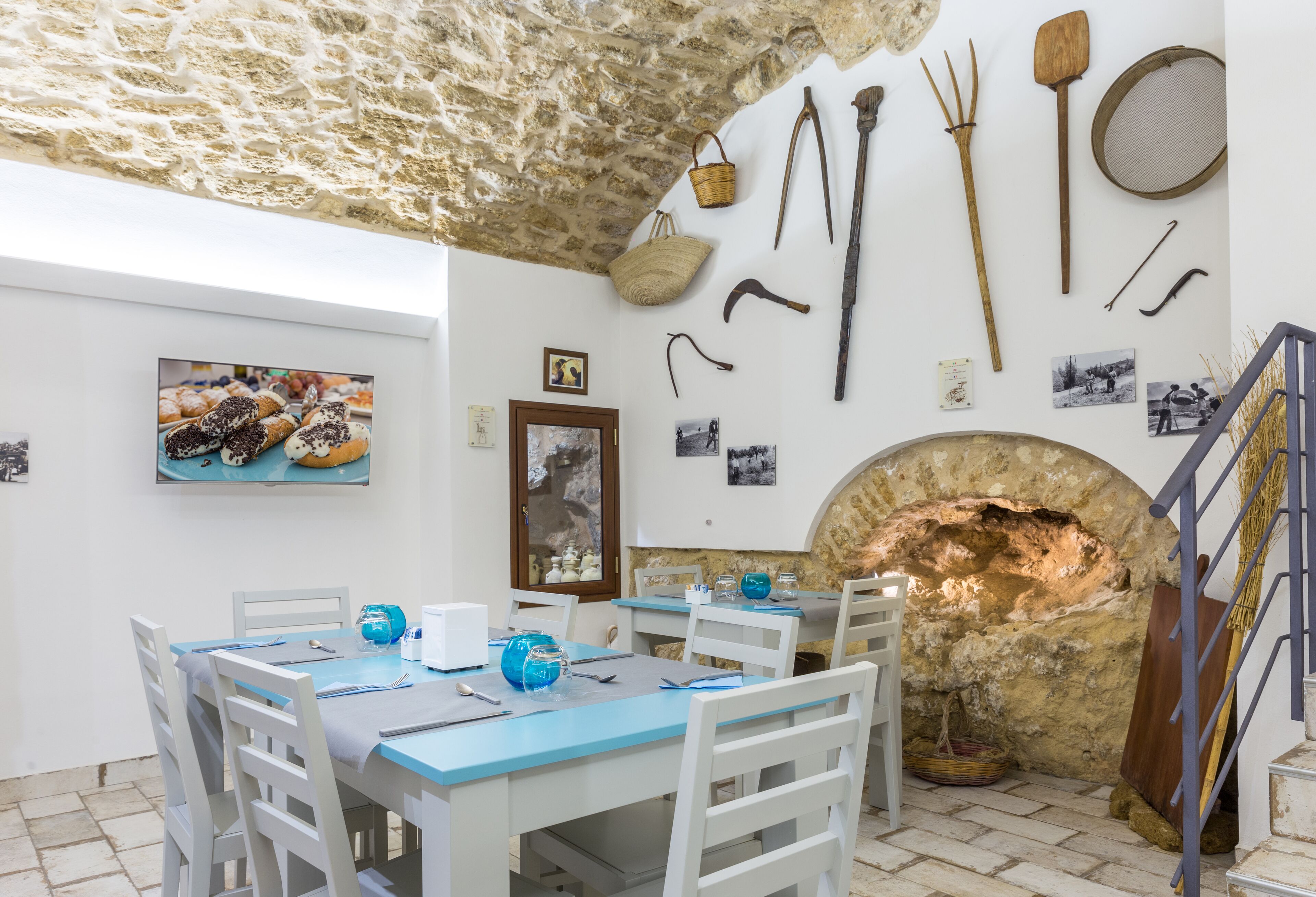 Un comedor con techo de piedra, decoración rústica y un horno de piedra.