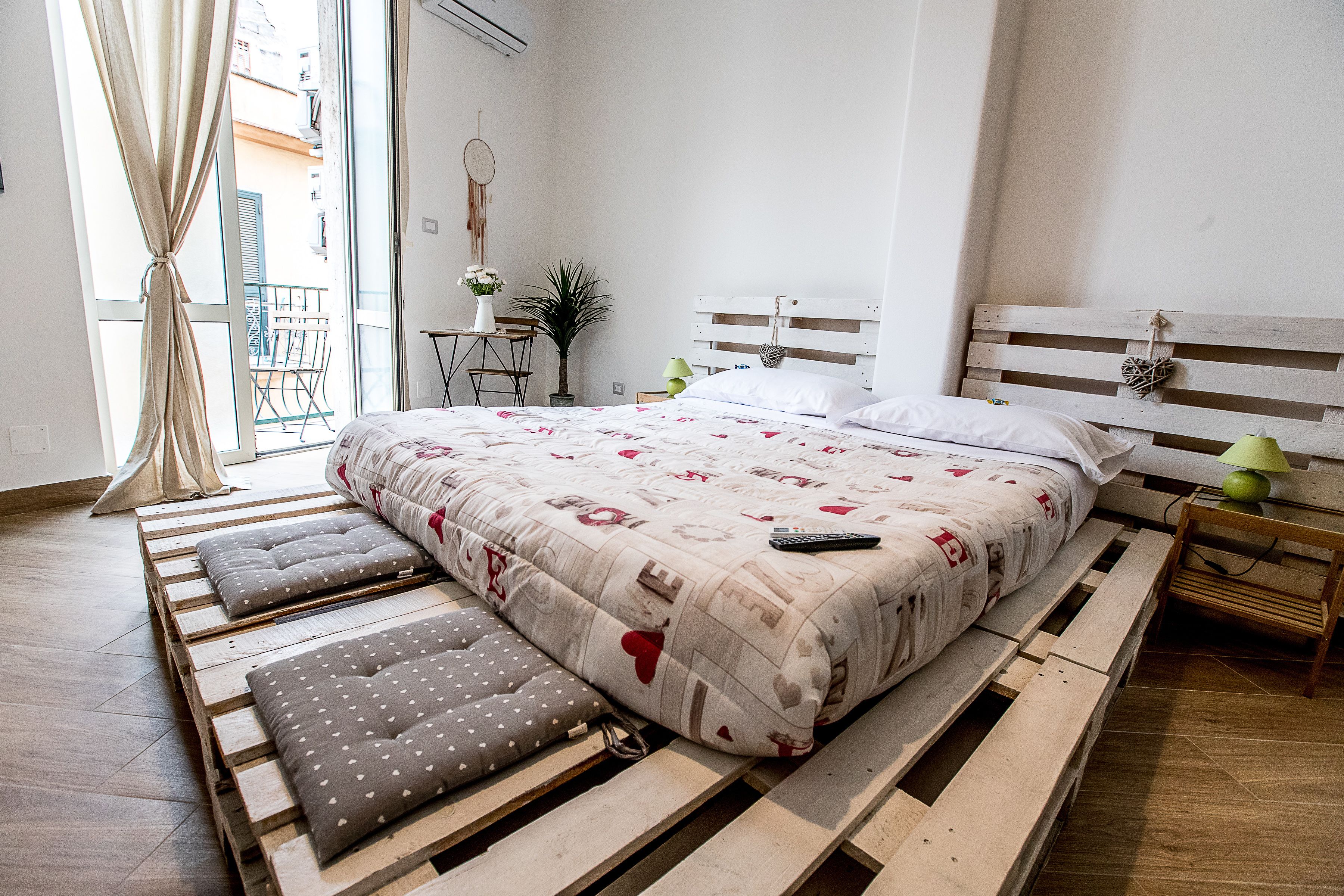 Une chambre à coucher avec un lit en bois, une tête de lit blanche et une table de chevet avec une lampe.