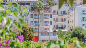 A multi-story hotel with balconies, surrounded by lush greenery and flowers. - Hotel No37 (Kas)