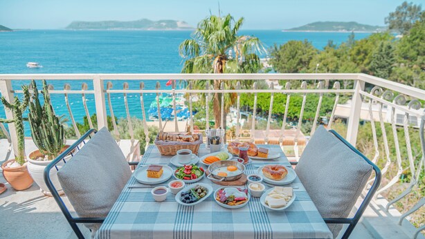 A balcony with a table set for breakfast overlooking the sea. - Hotel No37 (Kas)
