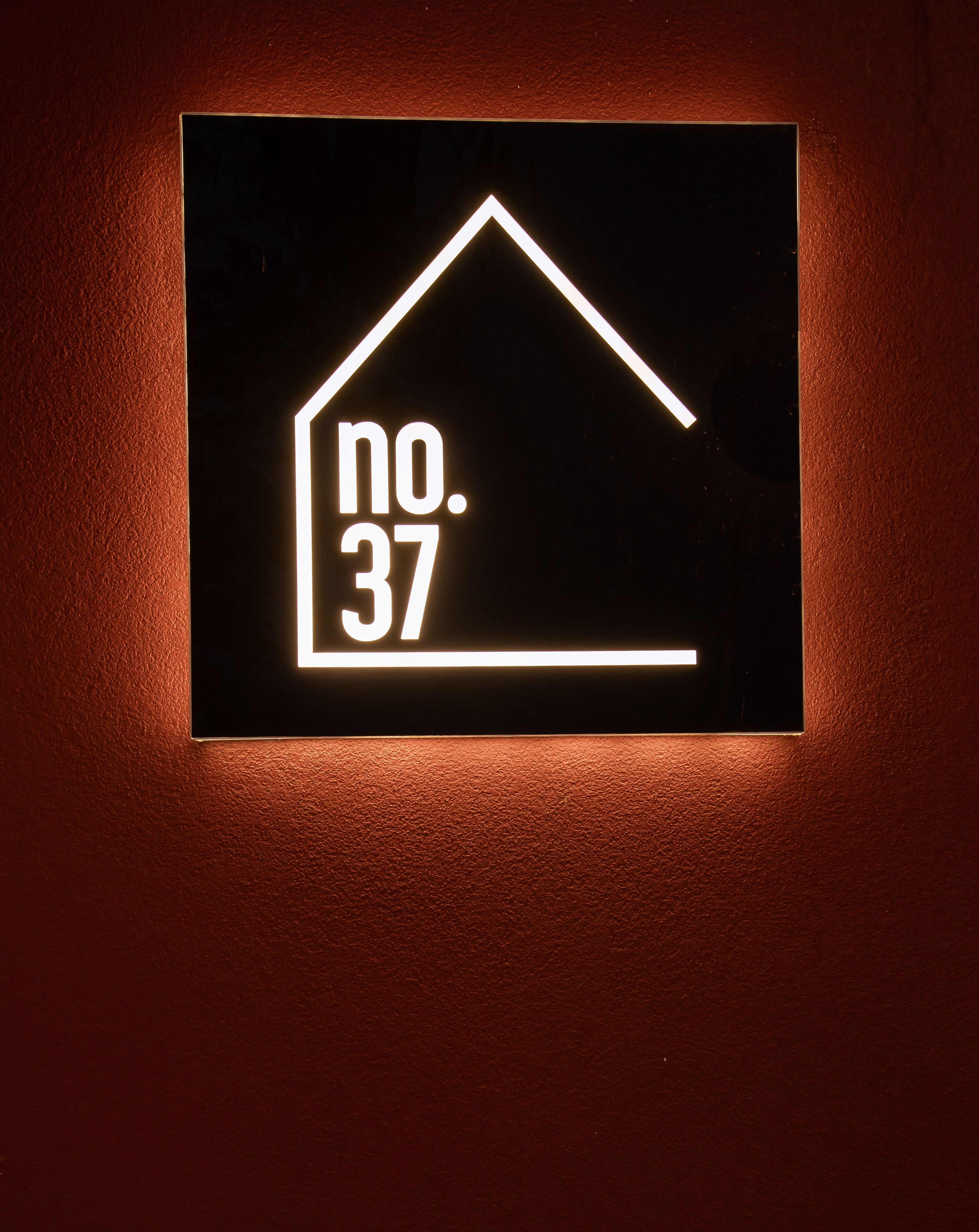 A sign with a house outline and the number 37.